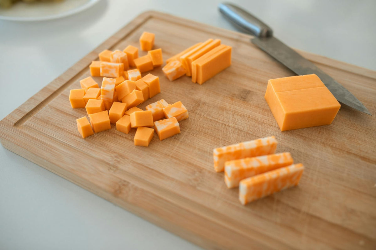 Pawvanti bacon and cheese soft and chewy dog treats with bacon strips and cheese pieces on a white surface.
